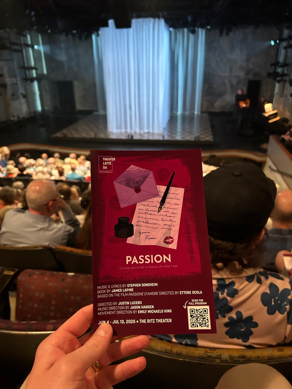 A hand holding up a program for Theater Latté Da's production of the Stephen Sondheim and James Lapine musical Passion